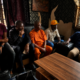 Five community stakeholders seated during a meeting and discussion in an indoor setting in Nigeria.